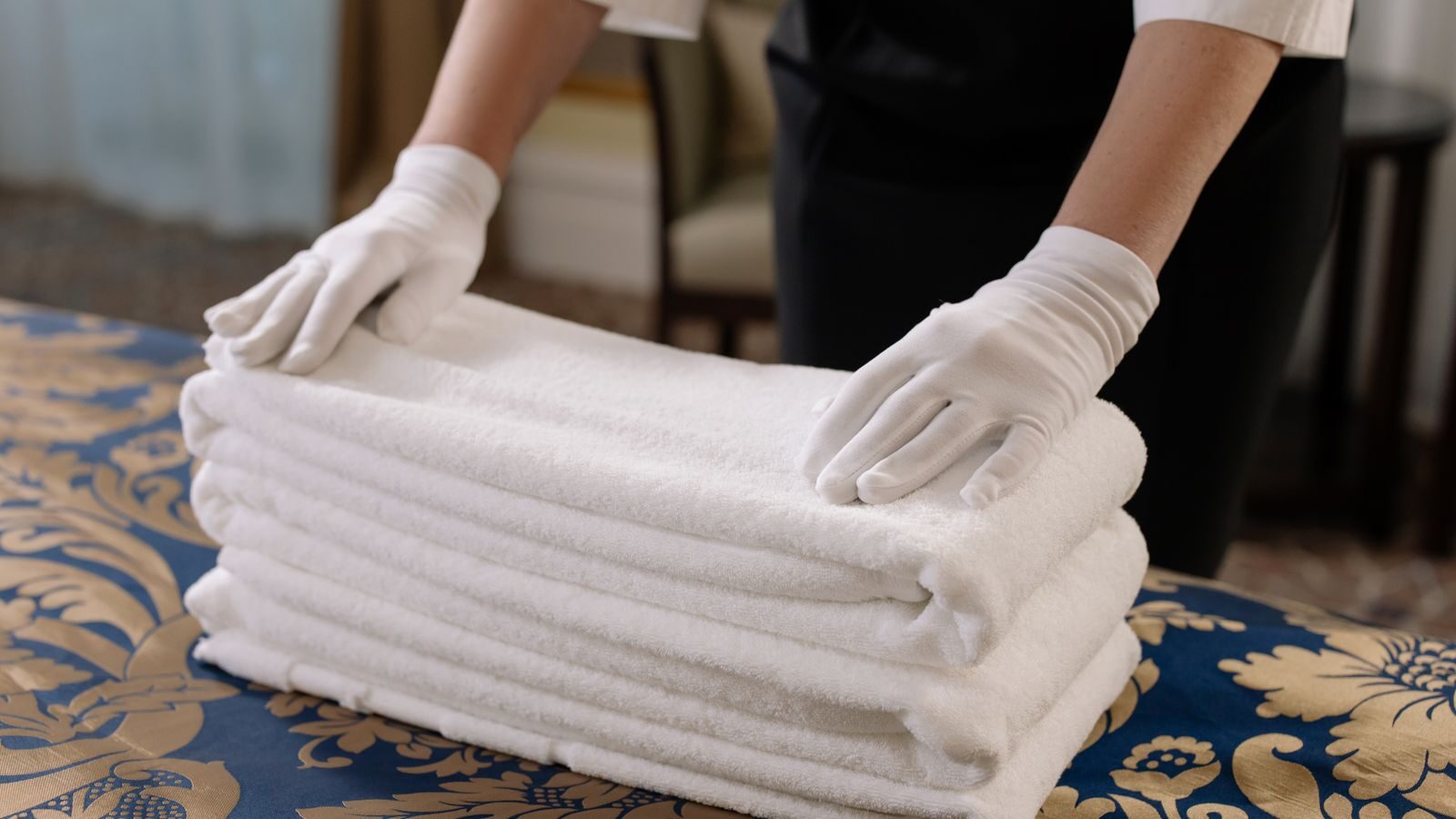 Profesional de limpieza preparando la ropa de cama y las toallas de un piso turístico en Bilbao entre dos estancias